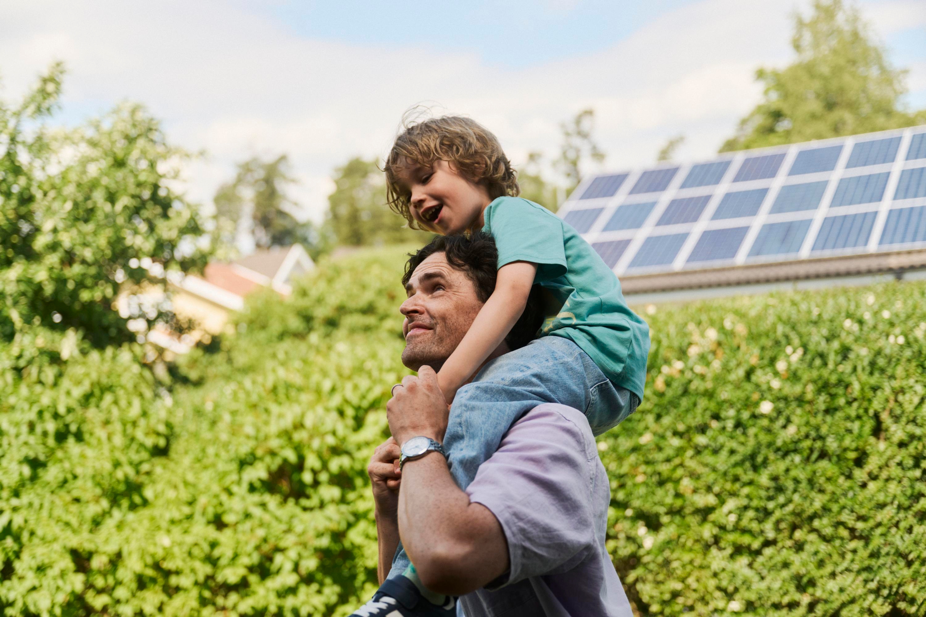 En man bär ett barn på sina axlar