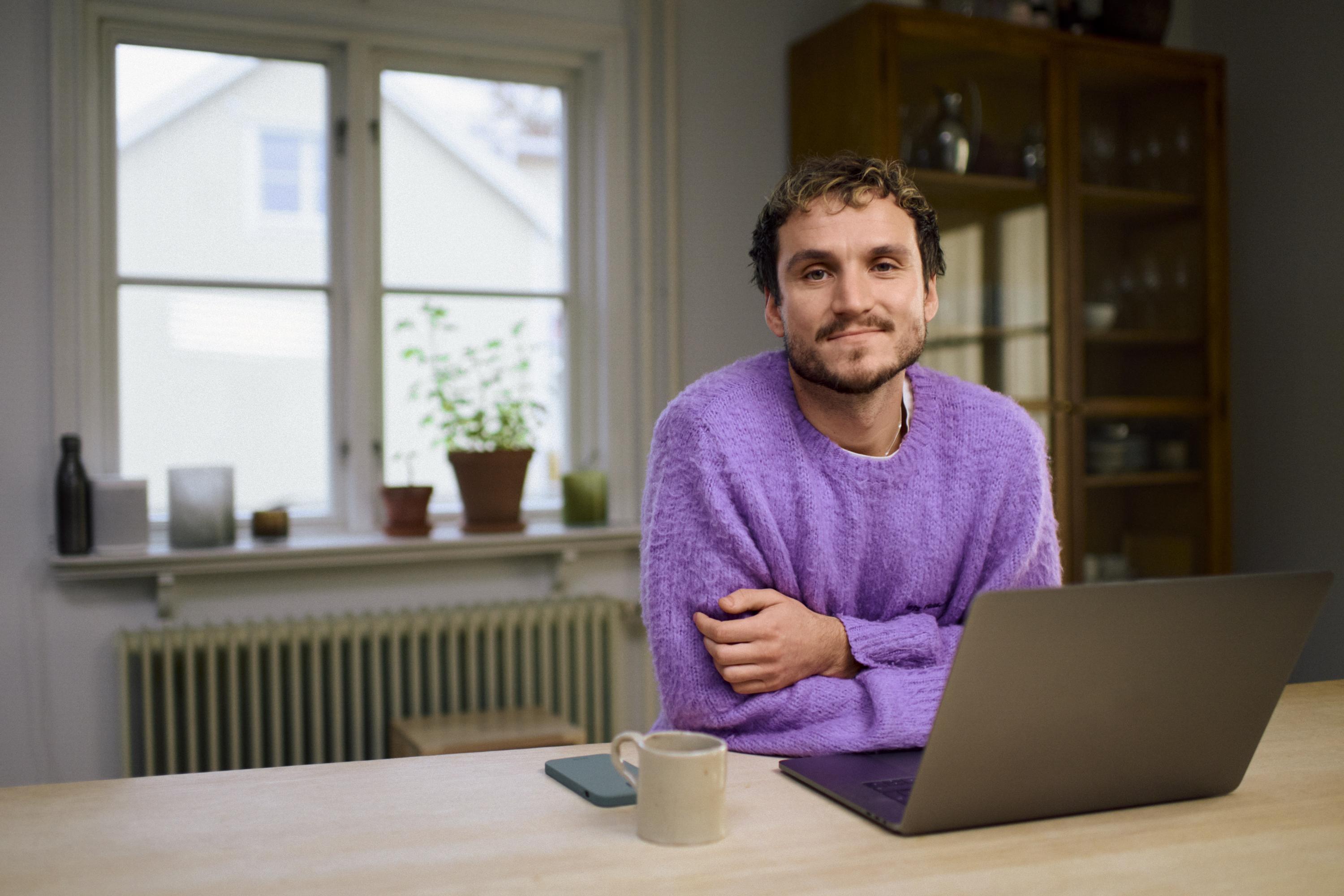 “Två kvinnor sitter vid ett bord och tittar leende på en bärbar dator. Den yngre kvinnan skriver på tangentbordet medan den äldre lutar huvudet mot handen och ser glad ut.”