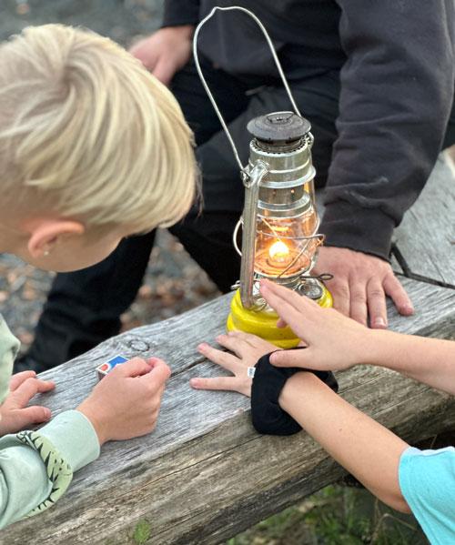 Barn tittar på en tänd oljelampa