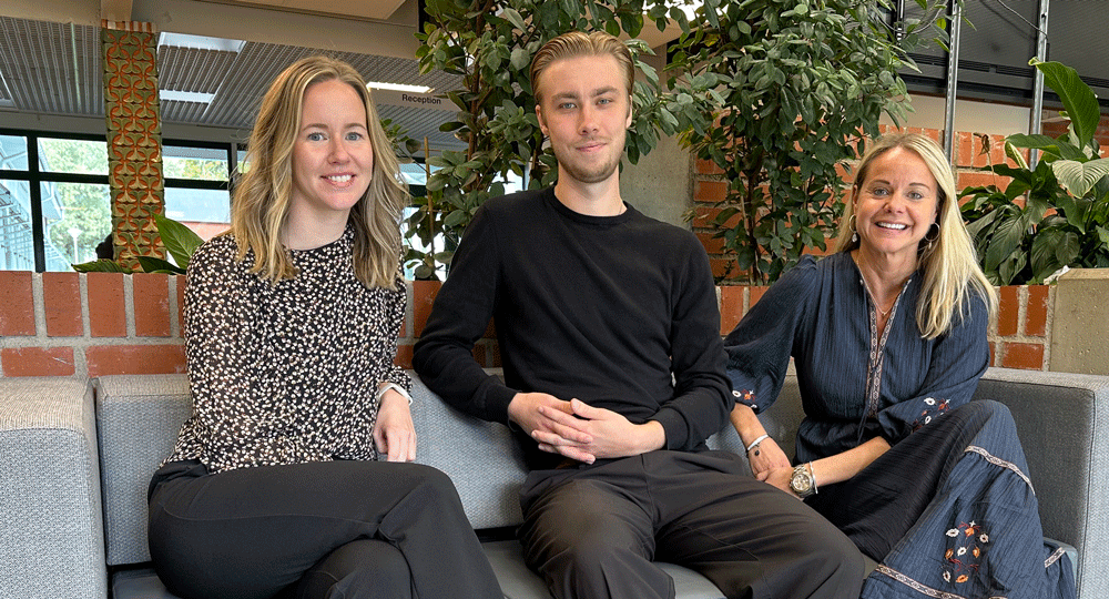 Fyra unga personer står bakom ett UF-företagsbord 